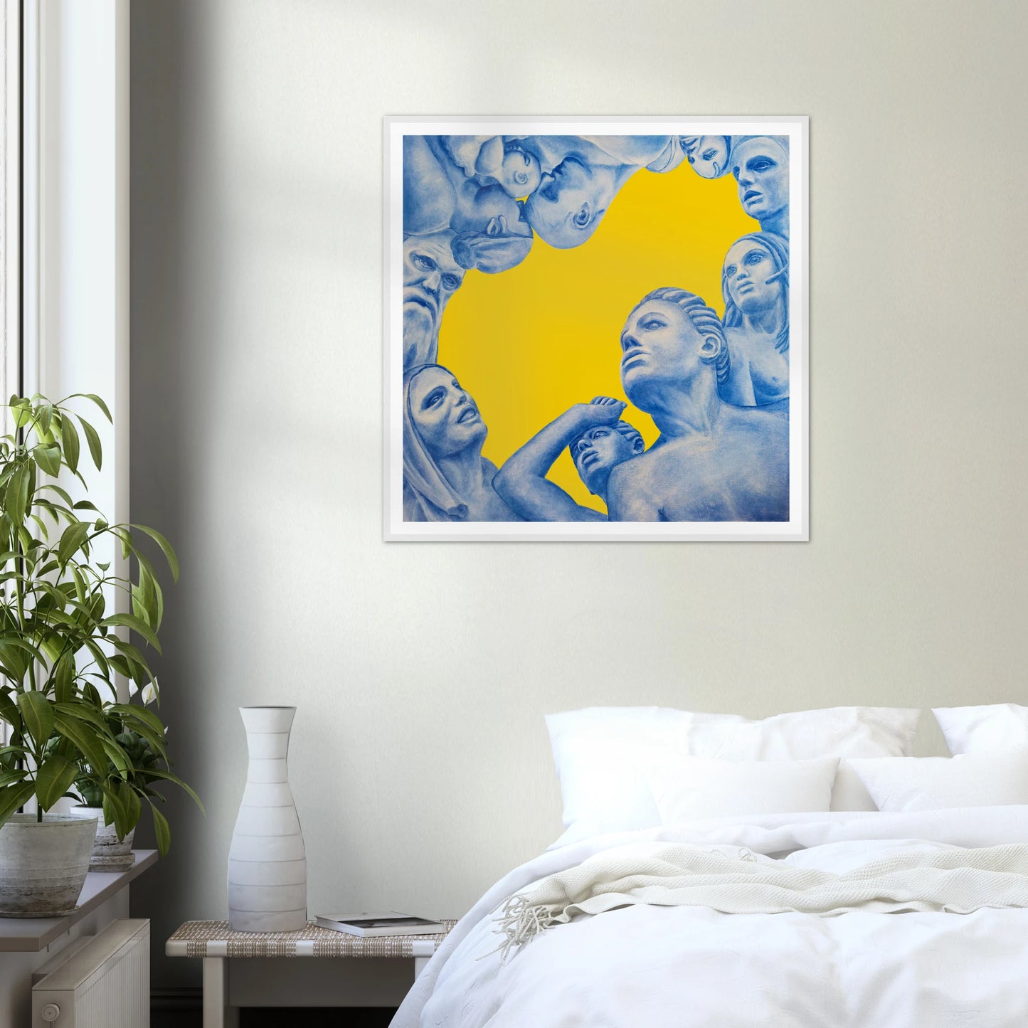 Framed artwork with blue figures against a yellow background in a bedroom setting.