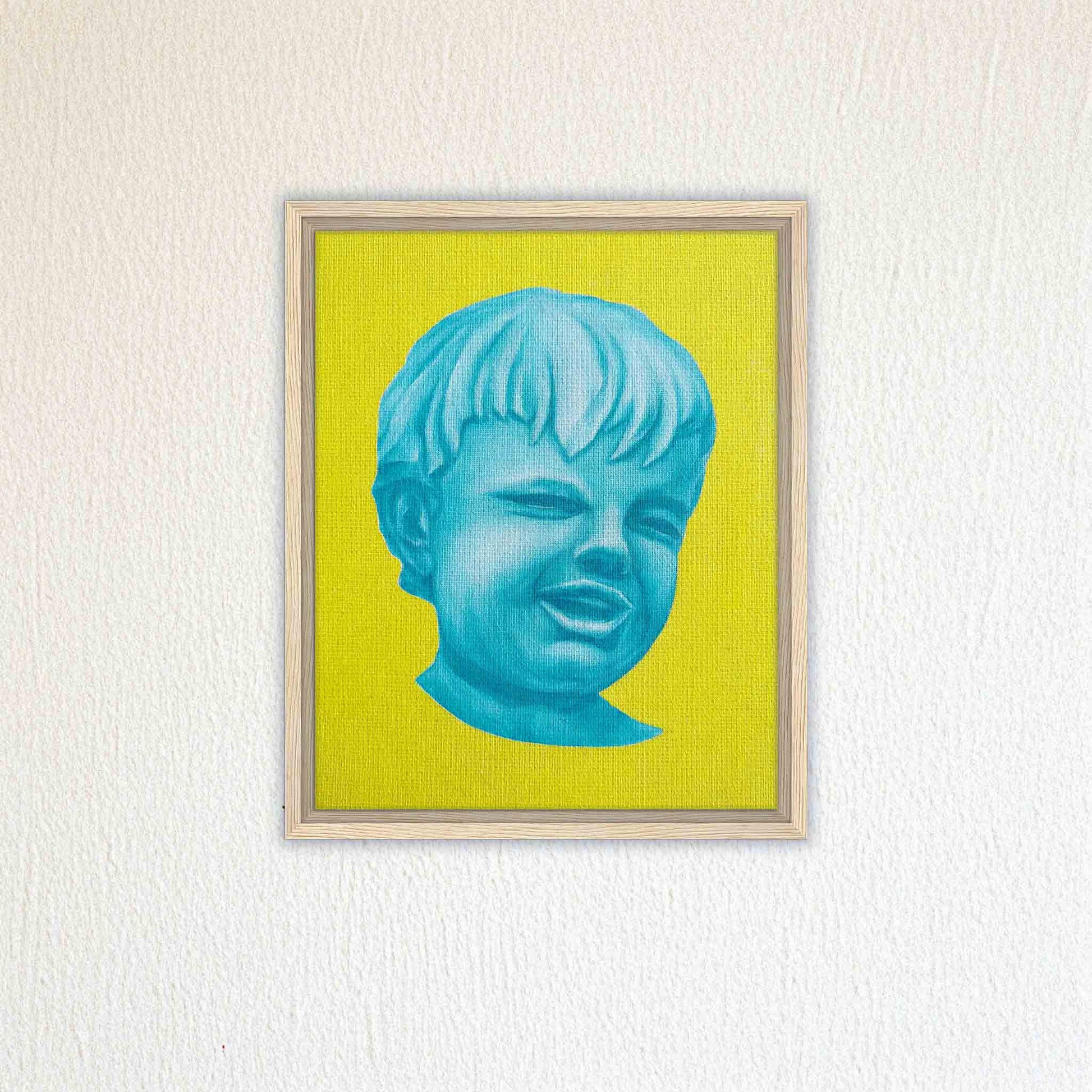Framed artwork of a blue face on a yellow background, mounted on a textured white wall.