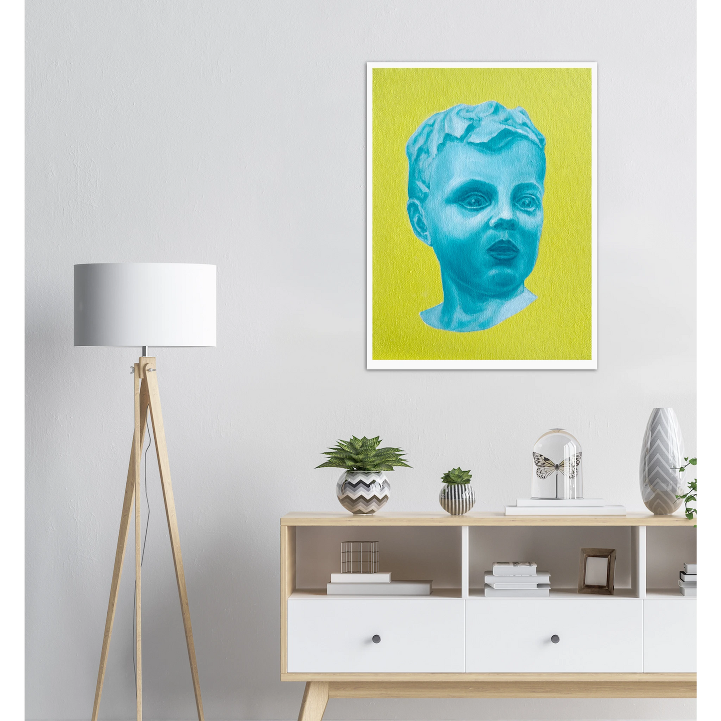 Framed artwork of a blue portrait on a yellow background in a modern interior setting.