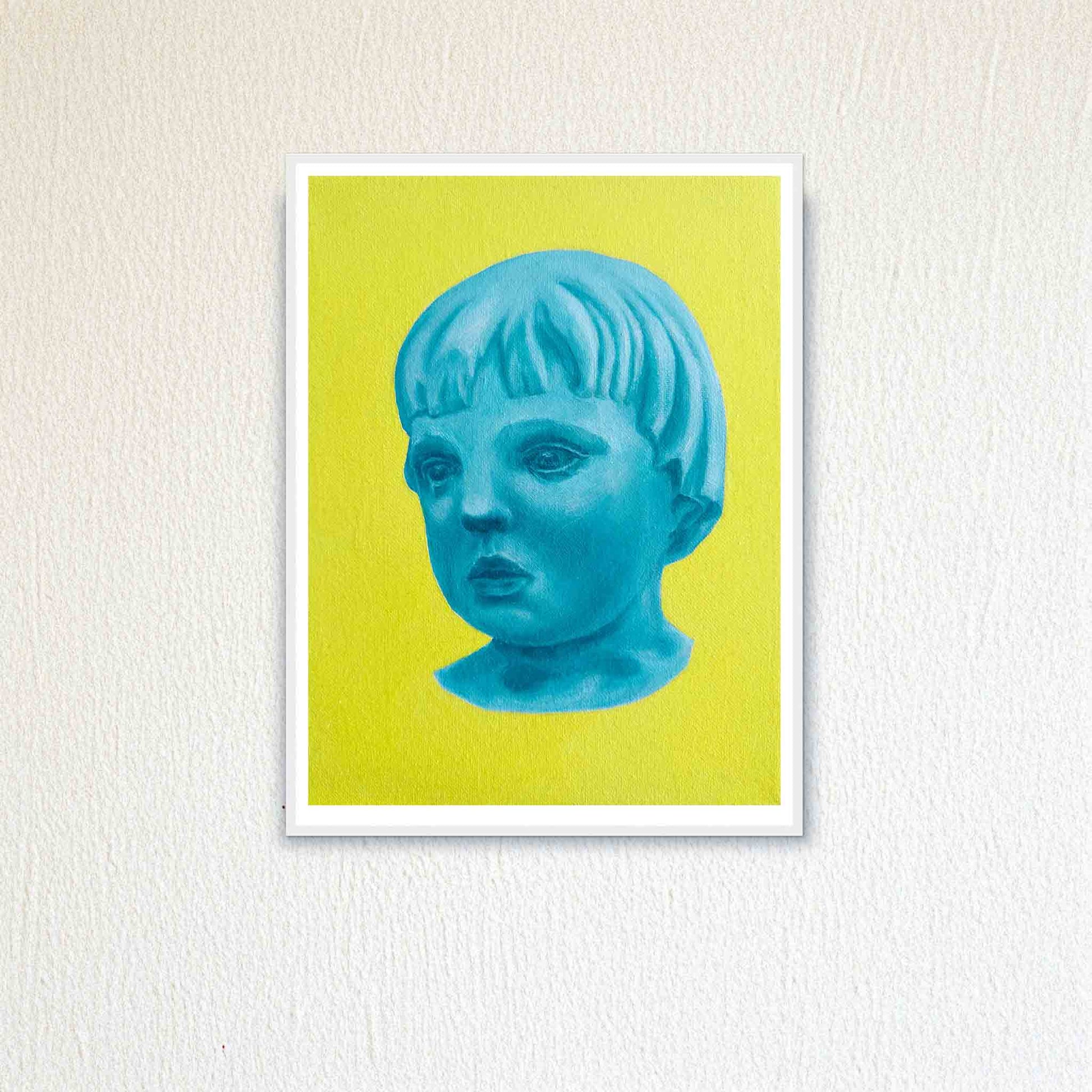 Framed artwork of a blue portrait against a yellow background on a textured white wall.