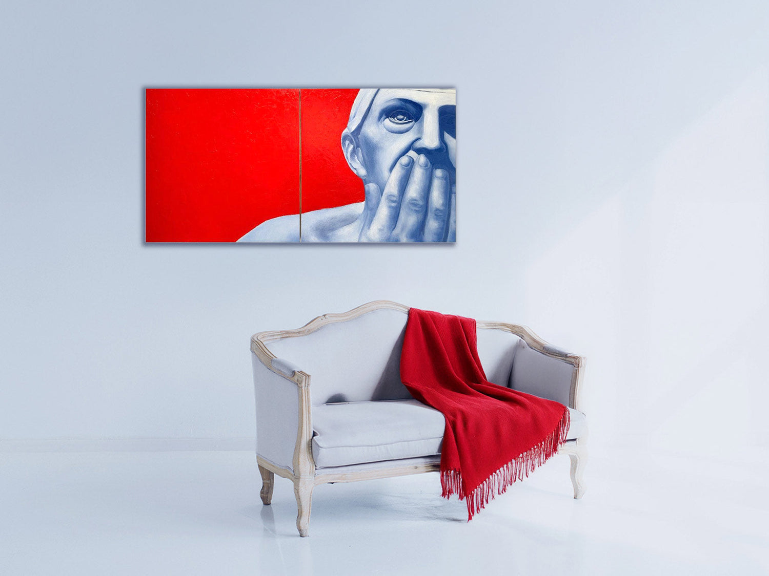 Interior with a sofa and a painting of a woman's face on a red background