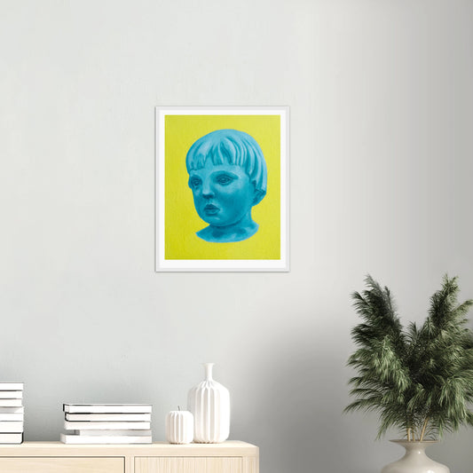 Framed artwork of a blue face on a yellow background, displayed on a wall with decor elements.